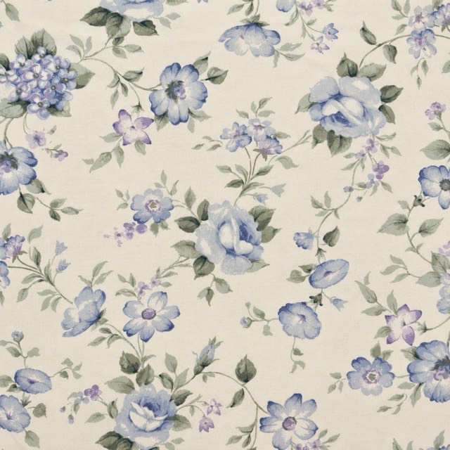 Soft blue and lavender flowers with sage leaves on cream.